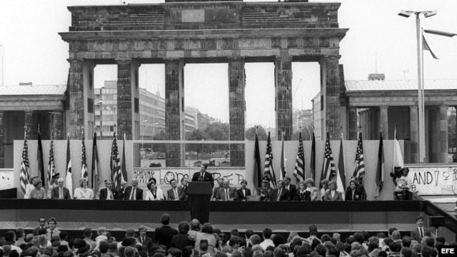 Fotografía de archivo del 12 de junio de 1987 que muestra al por entonces presidente de Estados Unidos Ronald Reagan (c) y al canciller alemán Helmut Kohl (a la derecha de Reagan) durante una ceremonia en el lado oeste del Muro de Berlín (Alemania), frent