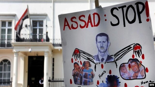 Un cartel anti presidente sirio Bachar al Asad frente a la embajada siria en Londres, Inglaterra, como protesta por la matanza de civiles el pasado viernes en la ciudad siria de Hula. 