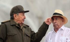 Raúl Castro bromea con el vicepresidente, José Ramón Machado (i-d), durante el desfile por el Día de los Trabajadores en La Habana.