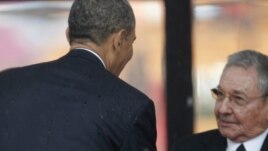 El presidente Barack Obama saluda a Raúl Castro en el servicio religioso por la muerte de Nelson Mandela.