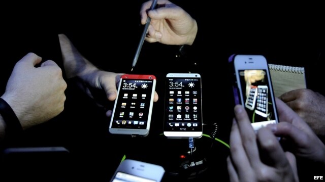 Varias personas prueban el nuevo modelo de teléfono inteligente de la marca HTC, el HTC One, en un evento de Nueva York, EE.UU. 