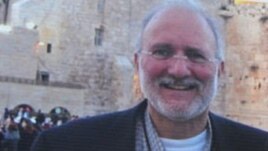 Una persona sostiene una pancarta en la que pide que sea liberado el contratista Alan Gross. 