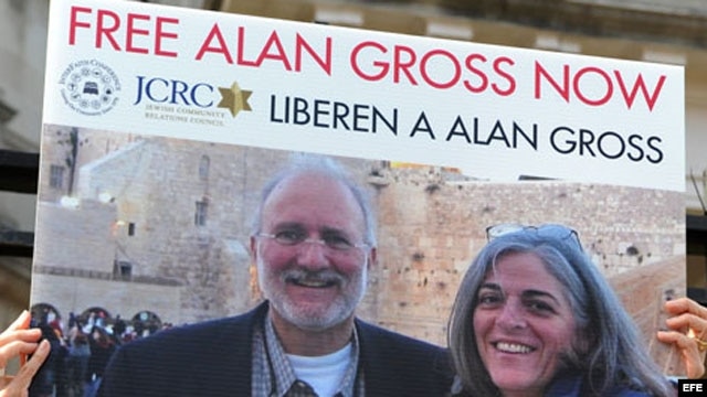 Una persona sostiene una pancarta en la que pide que sea liberado el contratista Alan Gross. 