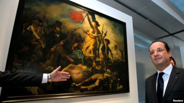 ARCHIVO. El presidente francés Francois Hollande posa delante de la obra "La Liberte Guidant le Peuple, 1830" de Eugene Delacroix.
