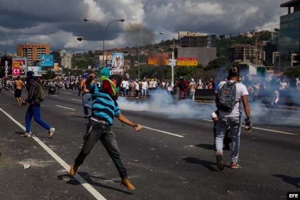 Un grupo de personas se enfrenta a miembros de la Policía Nacional Bolivariana al finalizar la marcha.