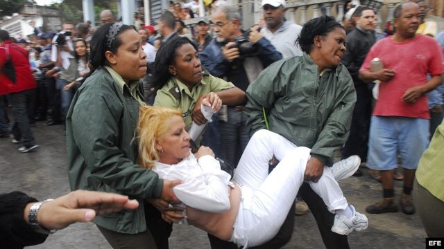 Agentes cubanos empujan, arrastran y suben a autobuses a Damas de Blanco. EFE/Rolando Pujol 