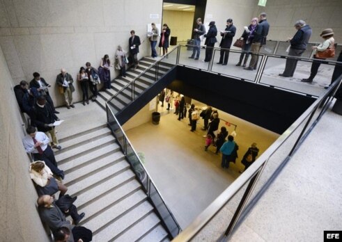 Unas personas hacen cola para votar en un colegio electoral ubicado en una biblioteca pública en Boston.