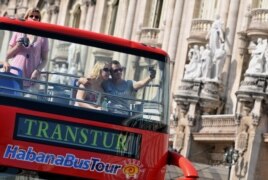Una pareja de turistas se toma una foto en un bus en La Habana.