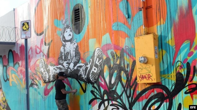 Un artista ultima detalles en un grafiti en Miami, Florida (EE.UU.). La zona de grafitis de Wynwood, el barrio artístico de Miami, reafirmará a partir del miércoles su condición de referente de las nuevas corrientes plásticas.