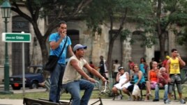 Dos hombres viajan en un triciclo por la zona colonial de La Habana (Cuba).