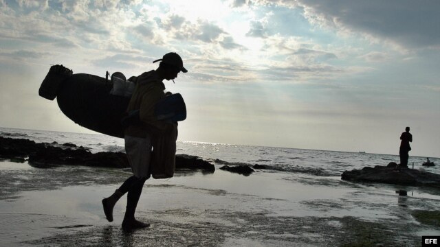 Archivo. Un pescador se dirige hacia el mar con sus utensilios de trabajo en una de las costas del litoral norte habanero. 