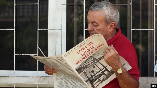 Un hombre lee la edición especial del "Granma", donde se divulga la Ley de Inversión Extranjera (abril, 2014).