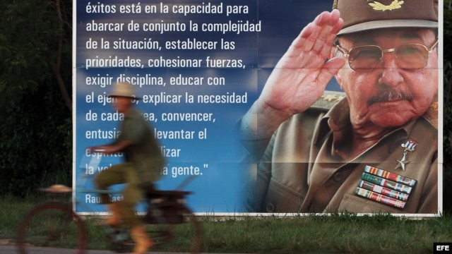  Un campesino pasea en bicicleta junto a un cartel con la imagen del presidente cubano Raúl Castro. en la provincia de Artemisa, Cuba.