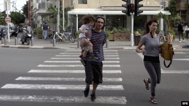 Una pareja israelí corre tras escuchar las sirenas de alarma en Tel Aviv, Israel