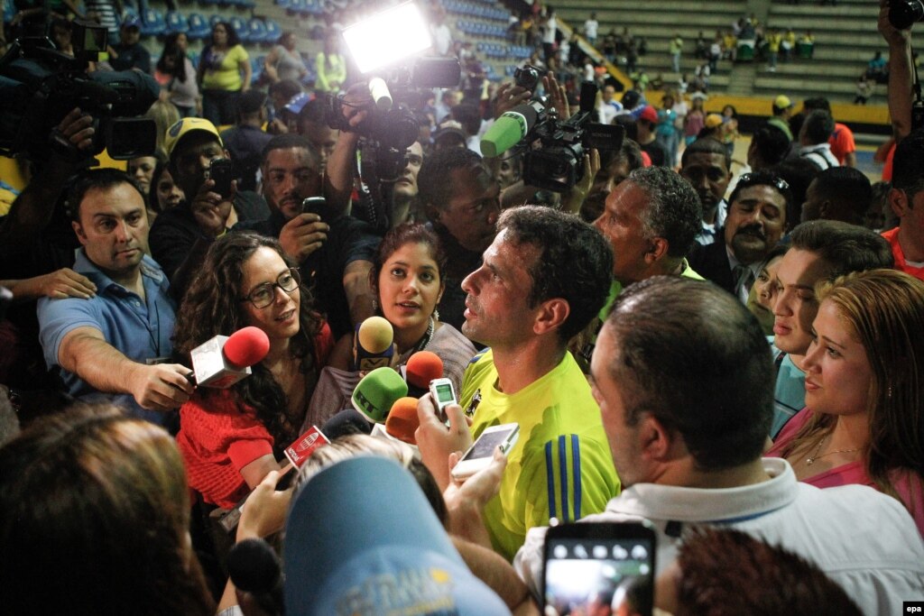  El candidato presidencial de la oposición a la presidencia de Venezuela, Henrique Capriles (c), habla con la prensa.  