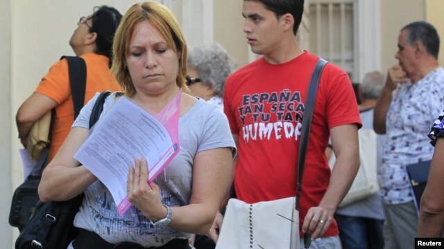 Una cubana revisa sus papeles tras visitar una oficina de inmigración en La Habana, Cuba. 