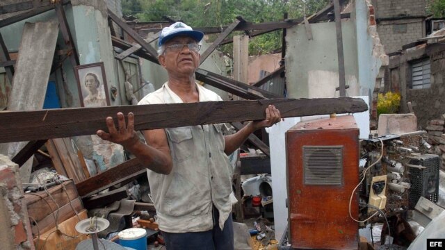  Un hombre rescata algunas pertenencias de su hogar, destruido por el paso del huracán "Sandy", en la ciudad de Santiago de Cuba. La urbe, en el este de la isla, fue una de las zonas más castigadas por el paso del huracán, con derrumbes de viviendas