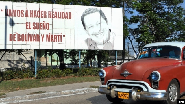 Un vehículo pasa frente a una valla con la imagen del presidente de Venezuela, Hugo Chávez, en La Habana.