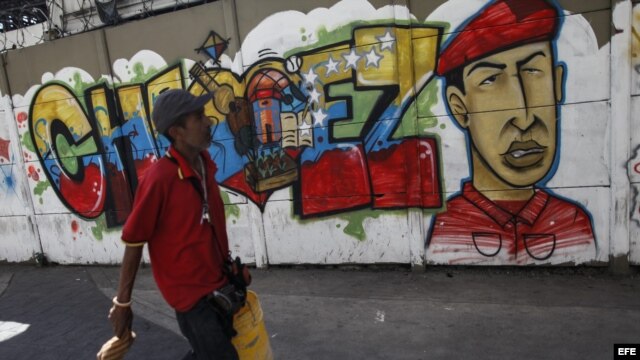  Transeúntes caminan frente a pintadas de apoyo al presidente Hugo Chávez, en el centro de Caracas, Venezuela