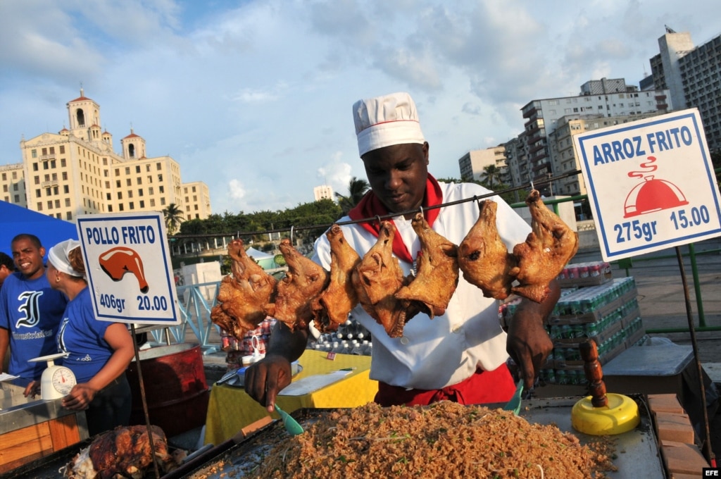 Fotografía de archivo. Un cocinero prepara arroz y pollo fritos en el Malecón de La Habana (Cuba). 