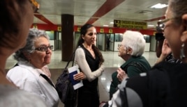 Rosa Maria Payá (c), hija del fallecido disidente Oswaldo Payá, espera el turno para realizar el chequeo de emigración acompañada de su madre Ofelia Acevedo, en el aeropuerto José Martí de La Habana (Cuba).