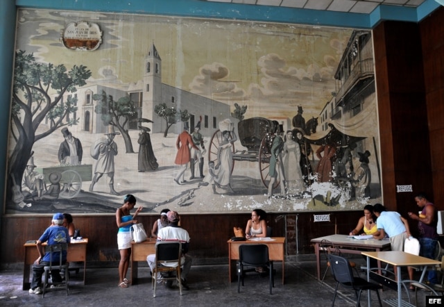 Varias personas son atendidas en una oficina municipal de trabajo. Los cubanos han acudido a las oficinas para preguntar por información sobre el empleo privado.