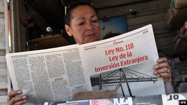 Una vendedora de periódicos lee un tabloide especial confeccionado por el diario Granma donde se divulga la nueva Ley de Inversión Extranjera. 