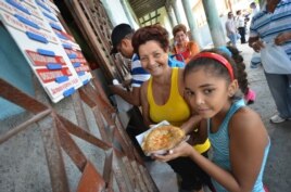 Varias personas compran pizzas en una cafetería gestionada por trabajadores por cuenta propia en La Habana.