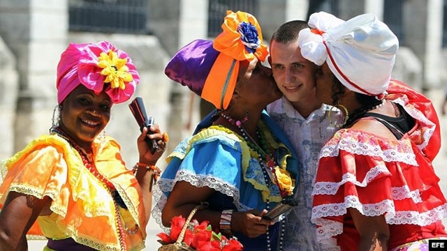 Un turista se toma fotos con mujeres cubanas.