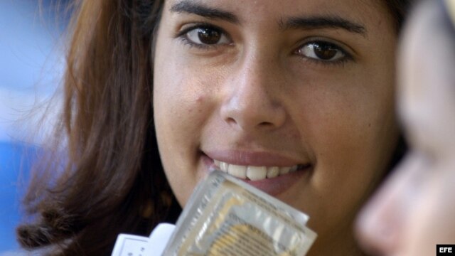 Una promotora de salud, que trabaja en el grupo de prevención de VIH-SIDA, muestra unos condones que fueron repartidos en La Habana (Cuba).