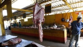 Archivo - Varios carniceros esperan la llegada de clientes en un agromercado de La Habana (Cuba). 
