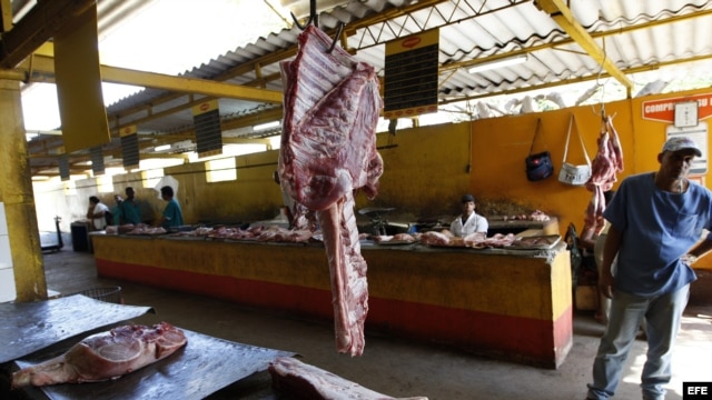 Archivo - Varios carniceros esperan la llegada de clientes en un agromercado de La Habana (Cuba). 