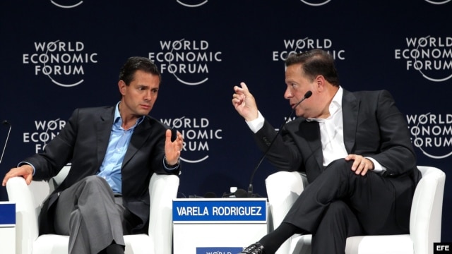 El presidente de México Enrique Peña Nieto habla con su homólogo de Panamá Juan Carlos Varela Rodríguez (i-d).