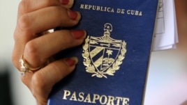 Una mujer muestra dos pasaportes cubanos en una oficina regional de la Dirección de Inmigración y Extranjería en La Habana (Cuba). 