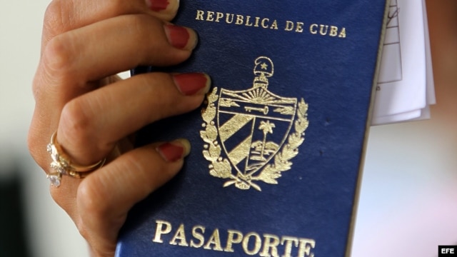 Una mujer muestra dos pasaportes cubanos en una oficina regional de la Dirección de Inmigración y Extranjería en La Habana (Cuba). 