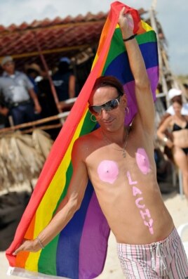 Un hombre sostiene la bandera gay en una playa de La Habana.