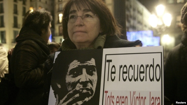 Una manifestante sostiene la imagen del cantautor chileno asesinado Victor Jara