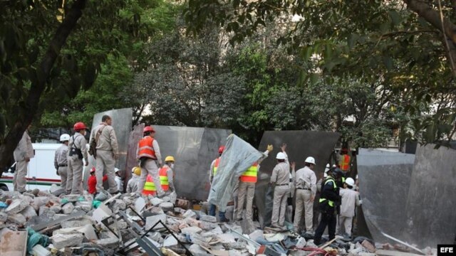 Empleados de la estatal Petróleos Mexicanos (Pemex) colocan lienzos para bloquear la visibilidad al interior del sitio donde ocurrió la explosión, en Ciudad de México. 