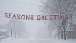 Un letrero de "Felices Fiestas" es cubierto por la nieve en una calle de Beaver Dam, estado de Wisconsin (EEUU). 