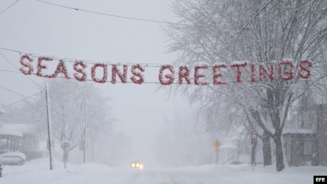 Un letrero de "Felices Fiestas" es cubierto por la nieve en una calle de Beaver Dam, estado de Wisconsin (EEUU). 