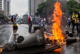 Opositores a Nicolás Maduro queman basura en la vía pública.