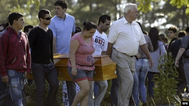 Familiares de las víctimas del incendio ocurrido en la discoteca Kiss de Santa María (Brasil) que causó 231 muertos, asisten a los funerales que se han iniciado hoy 28 de enero de 2013, en el cementerio de Santa Rita, a las afueras de Santa María. EFE/Nec