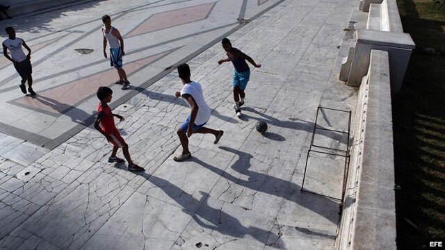  Jóvenes jugando fútbol en un parque en La Habana.