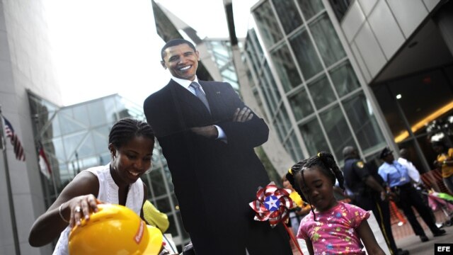Unos niños posan junto a una imagen del presidente estadounidense, Barack Obama, en el centro de Charlotte, Carolina del Norte, (EEUU). 