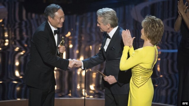 Fotografía facilitada por la Academia de Ciencias y Artes Cinematográficas (AMPAS) que muestra al director taiwanés Ang Lee (izda) recibiendo el Óscar al mejor director por "La Vida de Pi" de manos de Michael Douglas (centro) y Jane Fonda (dcha) en la gal