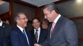 El presidente dominicano Danilo Medina (i) saludando al nuevo gobernador de Puerto Rico Alejandro García Padilla. 