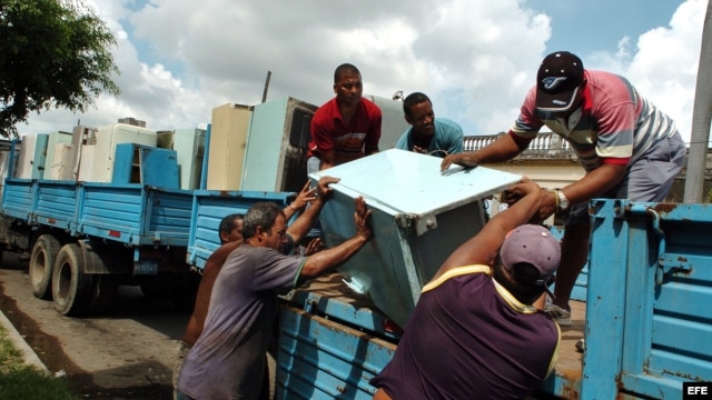 Varios hombres suben un viejo refrigerador a un camión. Centenares de frigoríficos soviéticos y americanos fueron recogidos para ser cambiados por económicos aparatos chinos que el Gobierno vendió a los cubanos. 