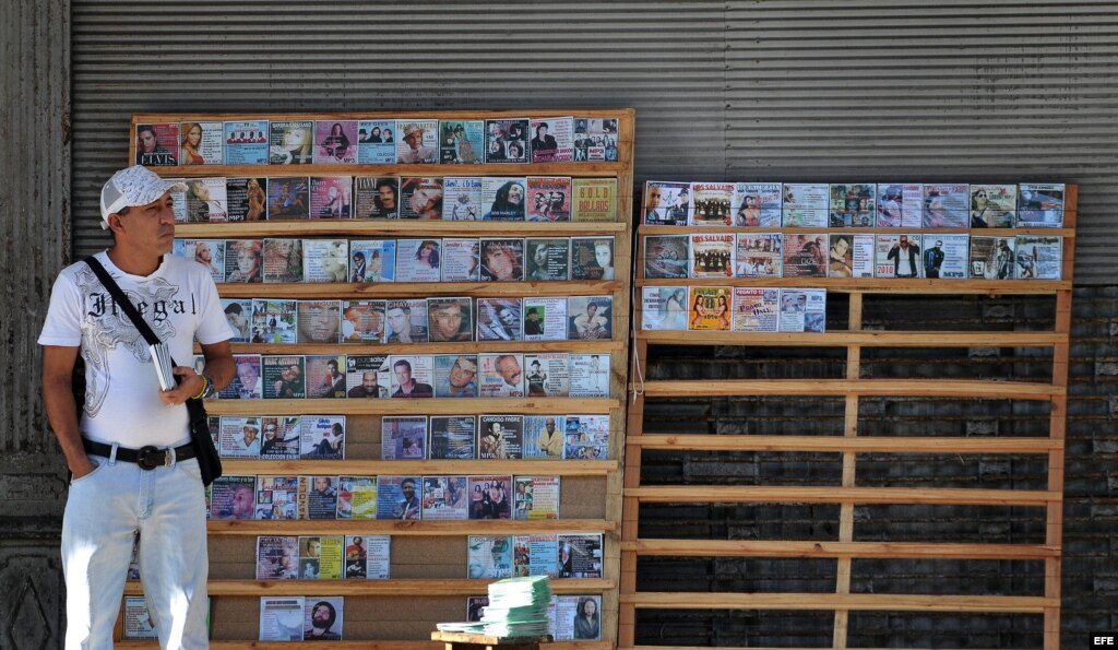 Un hombre vende copias piratas de CDs y DVDs en un pequeño puesto particular en La Habana