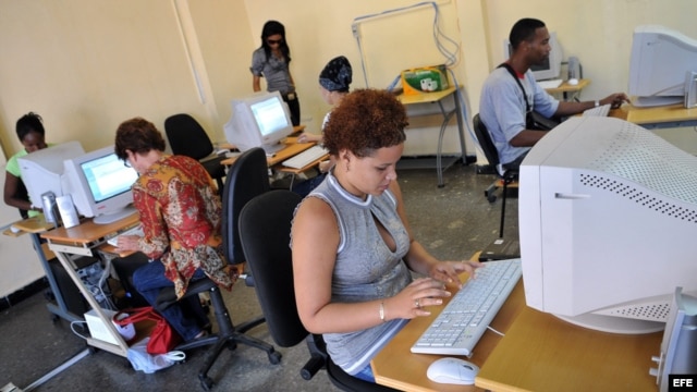 Varias personas consultan Intranet en una "sala de navegación", perteneciente a la empresa estatal Correos de Cuba. 