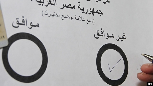 Un egipcio residente en los Emiratos Árabes Unidos rellena su voto para el referéndum sobre la nueva Constitución egipcia.